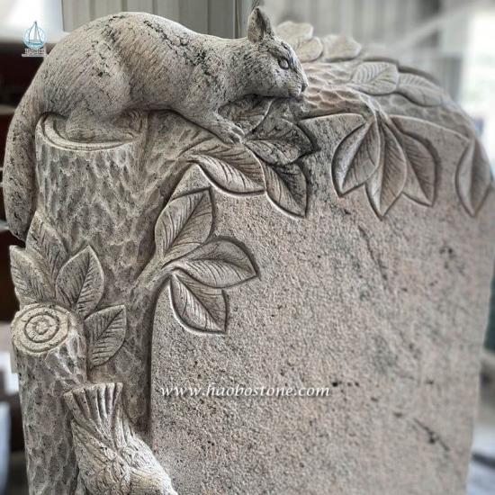 Aufrechter Grabstein aus grauem Granit mit geschnitztem Eichhörnchen

